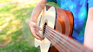 Boy playing guitar strings with fingers