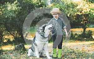 Boy playing with his dog in the park. Active children concept. Kids hiking in a park with a dog. Children and dog