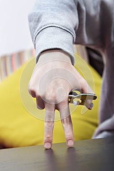 Boy is playing with his finger skateboard. Close up shot.