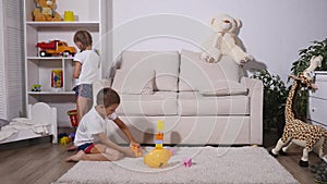 Boy playing with lego, and a girl with a rubik`s cube