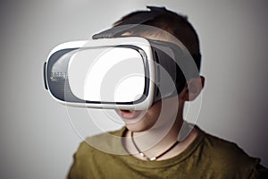 Boy playing mobile game app on device virtual reality glasses on white background. Boy action and using in virtual headset, VR box