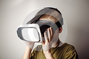 Boy playing mobile game app on device virtual reality glasses on white background. Boy action and using in virtual headset, VR box