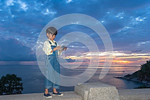 A boy playing on mobile at Promthep cape viewpoint