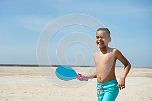 Boy playing paddle ball at the beach