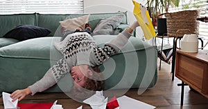 Boy playing with a paper airplanes and boats on sofa at home