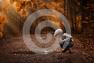 Boy playing with the paper boat