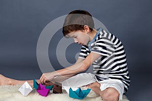 Boy playing with paper boats