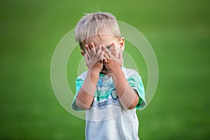 Boy playing peek-a-boo outdoors