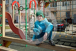 A boy is playing on playground in city yard