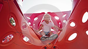 Boy playing on a playground, climbing, swinging, and sliding in the warm weather fun. Summer, Happiness, joy. Cute kids