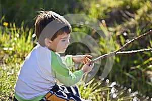 Boy playing by a pond on a sunny day