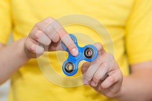 A boy is playing a popular toy fidget spinner in his hands. Stress relief. Anti stress and relaxation fidgets, spinner.