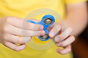 A boy is playing a popular toy fidget spinner in his hands. Stress relief. Anti stress and relaxation fidgets, spinner for tired.