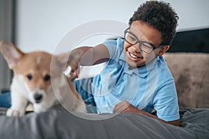 A boy playing with a puppy and looking involved