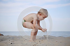 Boy playing sand beach picks sprinkles hands