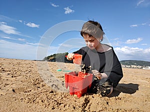 Boy playing with sand on the beach of San Sebastian