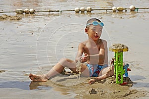 Boy playing sands in summer beach