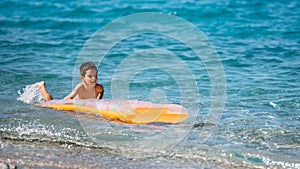 Boy playing in the sea with air mattress