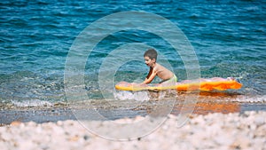 Boy playing in the sea with air mattress