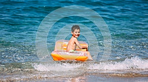 Boy playing in the sea with air mattress