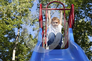 Boy Playing on a slide at the park photo