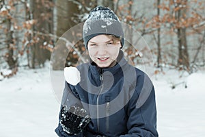 Boy playing with snowball outside