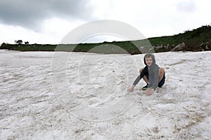 Boy playing on snowfield of Lago-Naki plateau