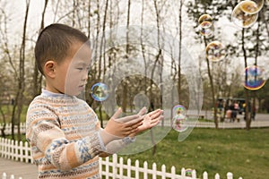 Boy playing soapbubbles