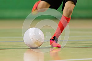 Boy playing soccer football in a hall