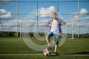 Boy playing soccer in the summer field