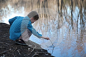 Boy playing with stick in water