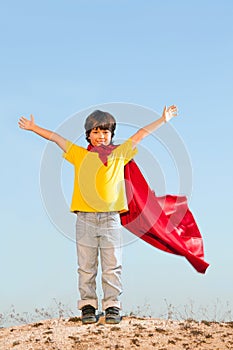 Boy playing superheroes on the sky backgrounde