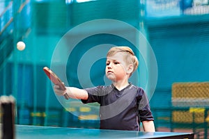 Boy playing table tennis indoors