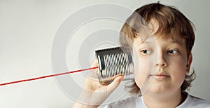 Boy Playing with Tin Can Phone. Isolated on grey Background