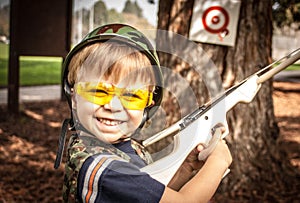 Boy playing with toy crossbow gun