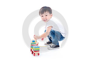 Boy playing toy on the floor over white background