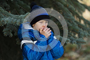 Boy playing with a toy gun on the street in autumn