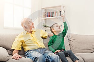 Boy playing with toy pane with his grandfather