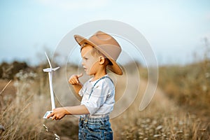 Boy playing with toy wind turbine outdoors