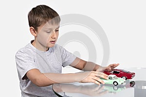 Boy playing with two toy cars