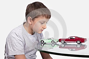 Boy playing with two toy cars