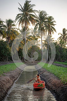 Boy playing in vegetables farm near the Damnoen Saduak floating market, Ratchaburi Province