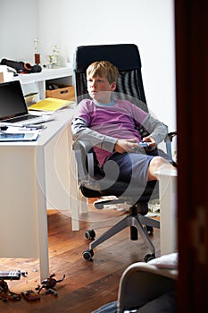 Boy Playing Video Game In Bedroom