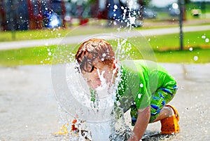 Boy playing in water fountain