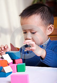 boy playing with wooden blocks