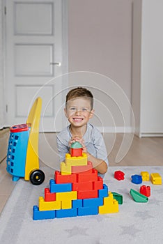 Boy plays with building blocks in kindergarten. The child is playing with colorful toy blocks at home