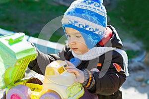 Boy plays with the car outdoor