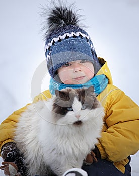 Boy plays with a cat outdoors