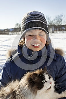 Boy plays with a cat outdoors