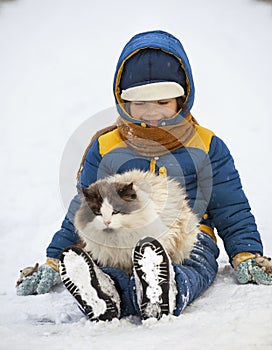 Boy plays with a cat outdoors